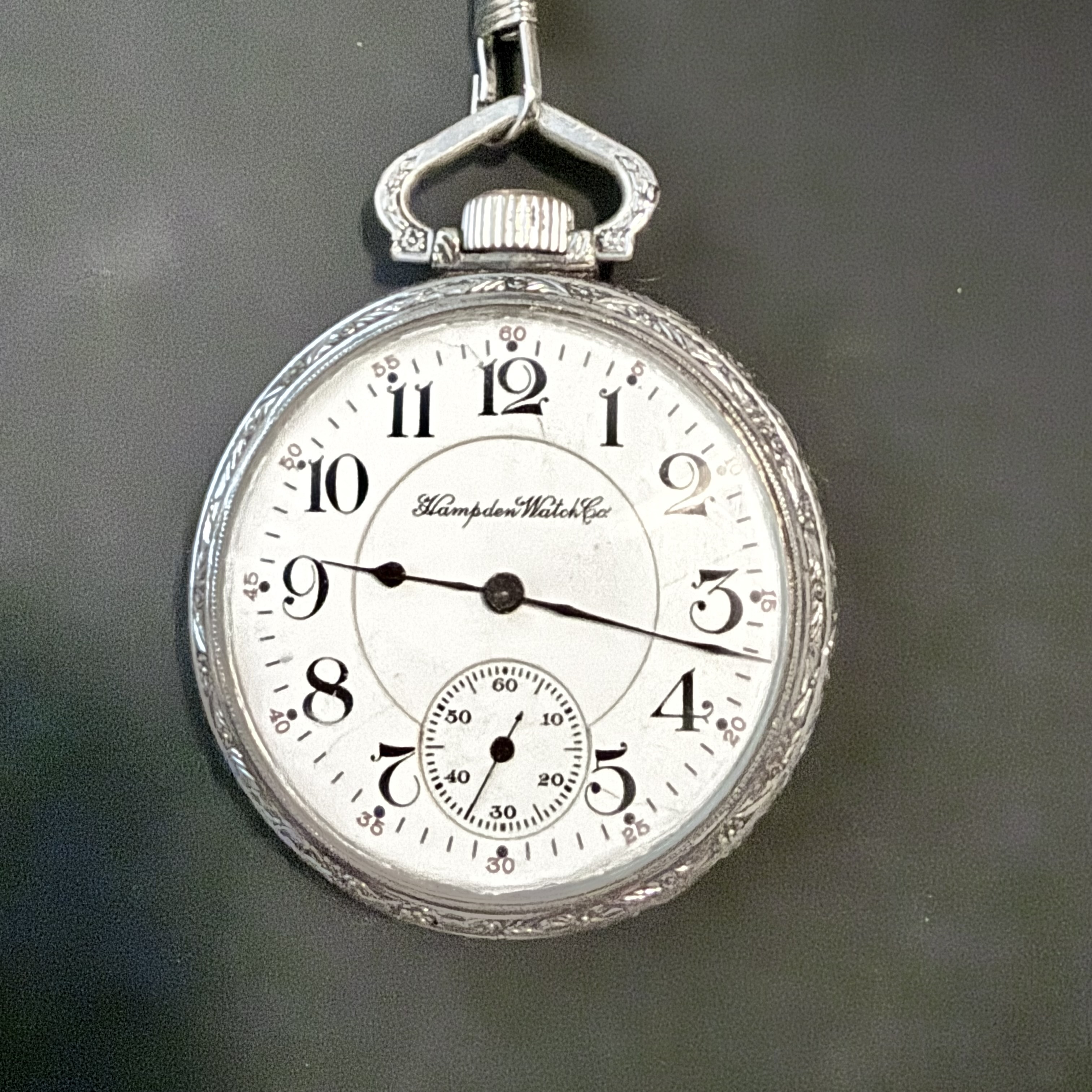 Hampden pocket watch photographed against a dark background